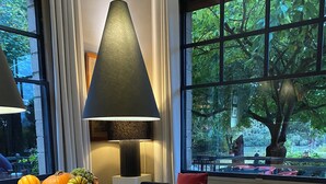 A modern dining area with a long wooden table, white chairs, a bowl of seasonal fruits, and a large window with a view of greenery. - Countryside Villa for Week-End ,week/holidays 1 Hour from Paris for 4/16 persons (Connelles)
