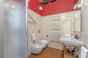 Bathroom features a sink, toilet, bidet, and a small plant.