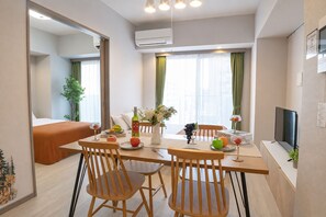A modern hotel room with a dining area, a bed, a TV, and a window with curtains. - Cure Azumabashi by Tranova (Tokyo)