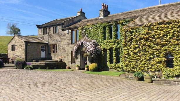 A stone building with ivy-covered walls and a cobblestone courtyard.