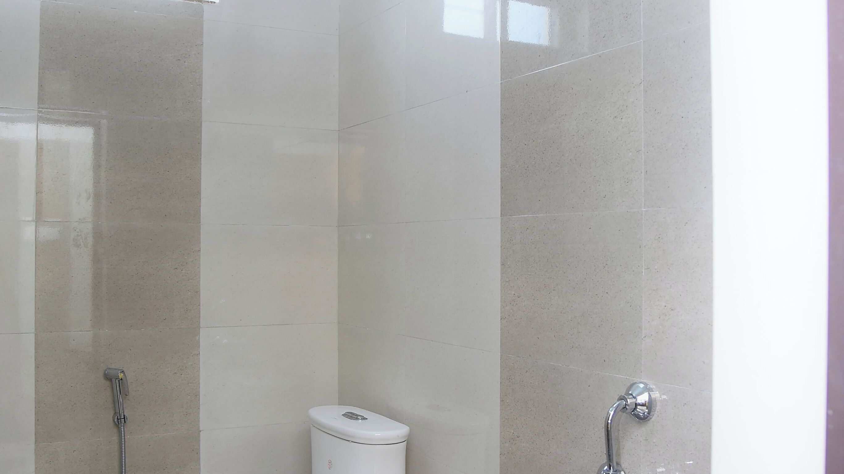 A bathroom with a toilet, a shower, and a sink.