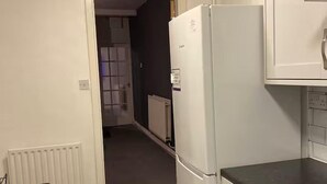 A narrow kitchen with a white refrigerator, a white countertop, and a white radiator. - 2br-sleeps3 -family Friendly -free Parking -garden (Nottingham)