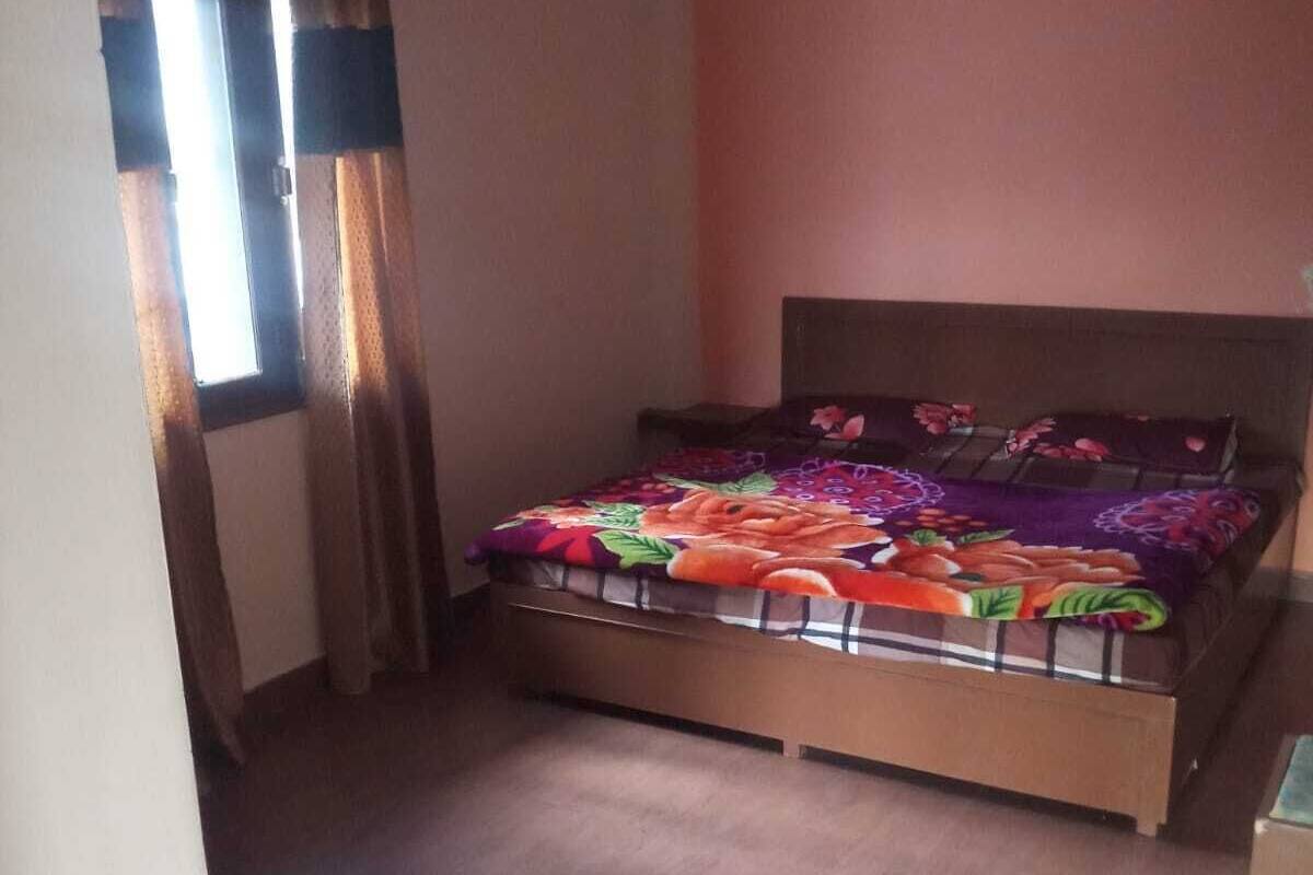 A bedroom with a bed, curtains, and a window.