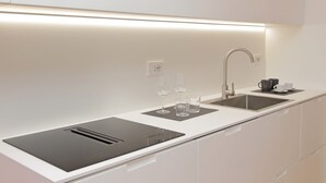 A modern kitchen with a sleek countertop, a built-in sink, and a stainless steel faucet. - 4bnb - Charming Giuliana Apartment (Rome)