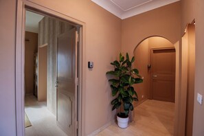 A hallway with a potted plant, a door, and a light fixture. - Boutique Suite Valadier (Rome)