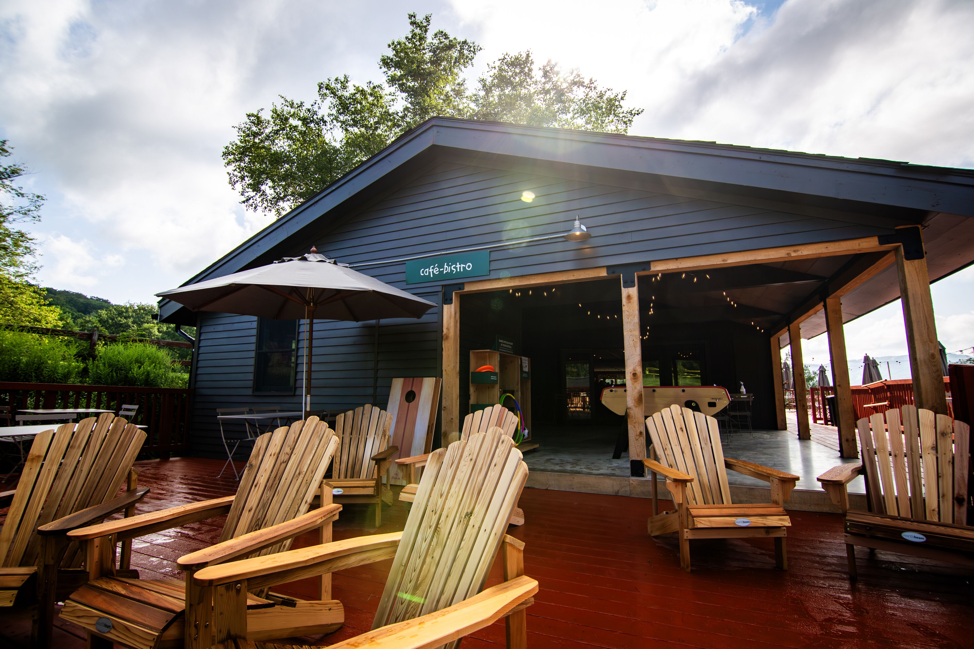 An outdoor seating area with wooden chairs and a cafe-bistro sign.