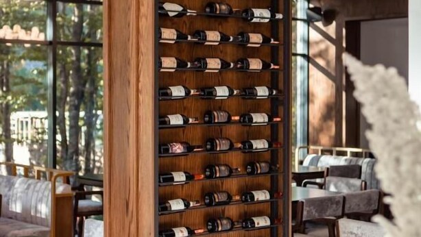 Una botellera con varias botellas en un ambiente interior moderno.