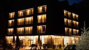 Un hotel de varios pisos con ventanas iluminadas y una entrada bien iluminada.