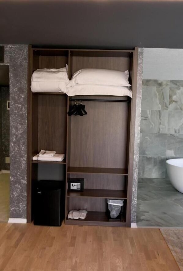 A walk-in closet with shelves, a small refrigerator, and a trash bin. - Hotel Valbor (Margegaj)