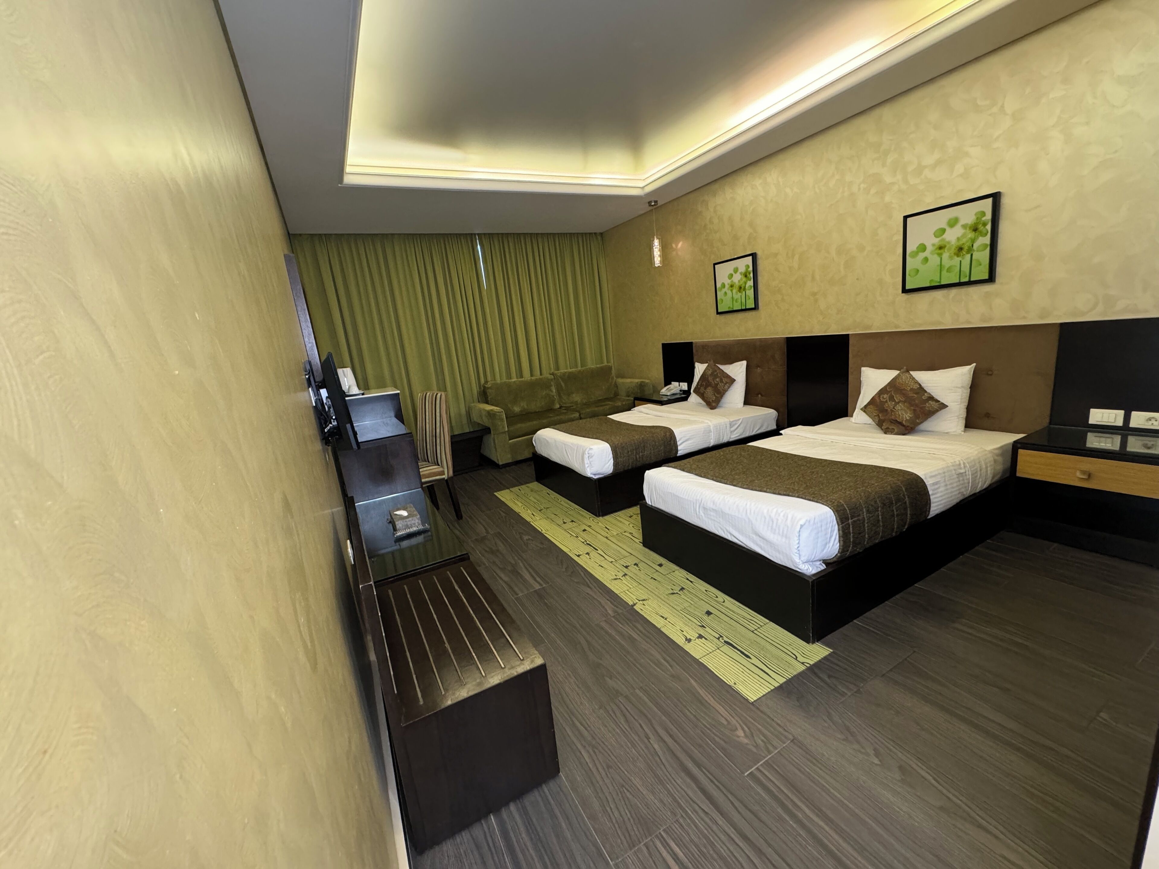 Une chambre d’hôtel avec deux lits, un bureau, une chaise et une petite table.