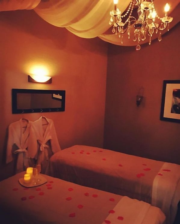 A room with two beds, a chandelier, a wall-mounted light, and a framed picture. - Elite Hotel By Beverly (Beirut)