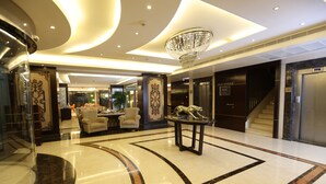 A spacious lobby with a marble floor, a chandelier, and a reception desk. - Elite Hotel By Beverly (Beirut)