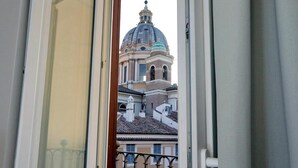 Une vue à travers la fenêtre d’un bâtiment doté d’un dôme et d’un clocher.