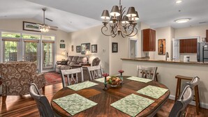 A dining room with a round table, chairs, and a chandelier. - 19th Hole 3 Bedroom Condo on the 9th Green (Maggie Valley)