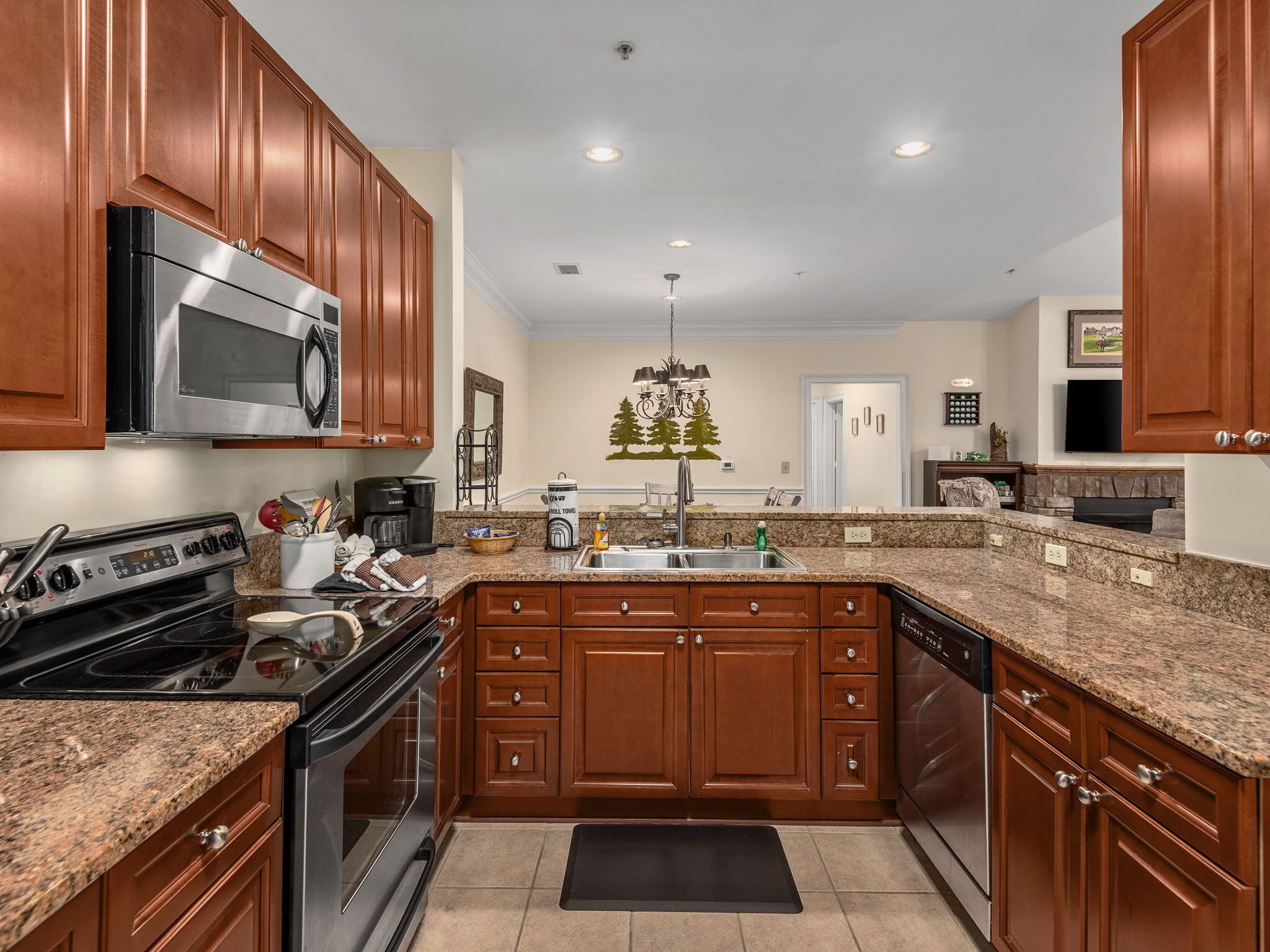 A kitchen with wooden cabinets, a stainless steel stove, a microwave, and a dishwasher.