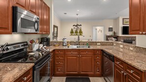A kitchen with wooden cabinets, a stainless steel stove, a microwave, and a dishwasher. - 19th Hole 3 Bedroom Condo on the 9th Green (Maggie Valley)