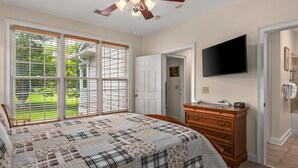 A bedroom with a large bed, a ceiling fan, a TV, and a dresser. - 19th Hole 3 Bedroom Condo on the 9th Green (Maggie Valley)