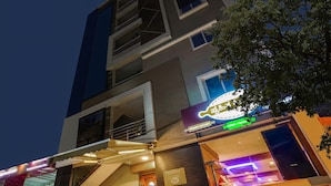 A modern building with a prominent sign for a restaurant. - RG Suites HSR (Bengaluru)
