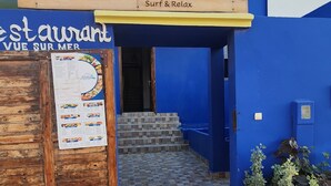 A blue building with a wooden sign reading "ALOHA Imsouane Surf & Relax". - Aloha imsouane chambres (Imsouane)