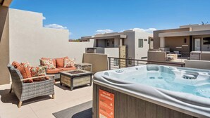 Terraza en la azotea con mobiliario exterior, bañera de hidromasaje y señal de seguridad.