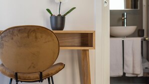 A bathroom with a wooden vanity, a white sink, and a mirror. - Design 18 Charming Rooms (Rome)