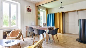 A dining area with a table, chairs, and a wicker chair.