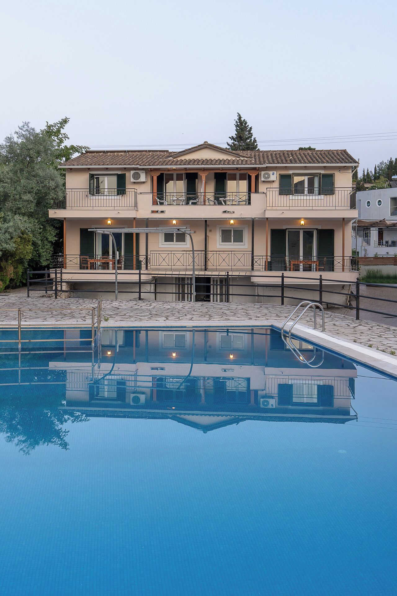 A two-story building with a swimming pool in front.