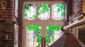 Une porte ornée de vitraux représentant des vignes et des feuilles.