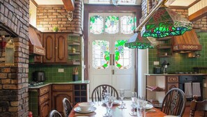 Un coin repas avec un mur en briques, des meubles en bois et un pare-feu vert en carreaux.