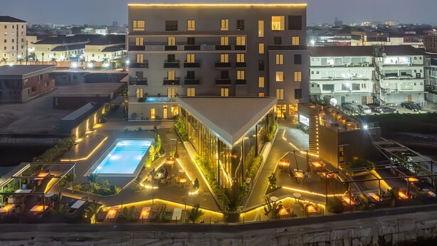 A modern hotel with a rooftop pool and outdoor seating areas. - Bickley Park Hotel (Lekki)