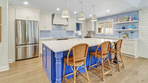 A modern kitchen with a central island, stainless steel appliances, and blue accents. - FULLY RENOVATED, Gorgeous 3 Bedroom Sea Pines Home - Private Pool - Golf View (Hilton Head Island)
