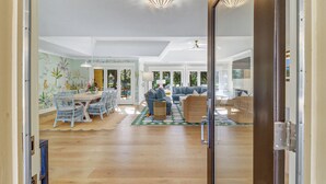 A spacious living area with a dining set, a sofa, and a coffee table. - FULLY RENOVATED, Gorgeous 3 Bedroom Sea Pines Home - Private Pool - Golf View (Hilton Head Island)