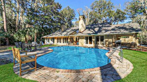 A pool area with a covered patio, lounge chairs, and a barbecue grill. - FULLY RENOVATED, Gorgeous 3 Bedroom Sea Pines Home - Private Pool - Golf View (Hilton Head Island)