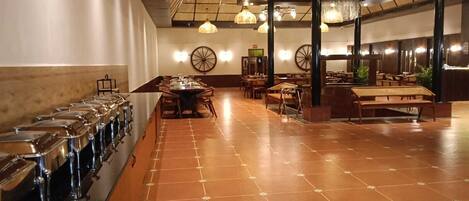 Un área de bufé con varias estaciones de servicio y una larga mesa con sillas.