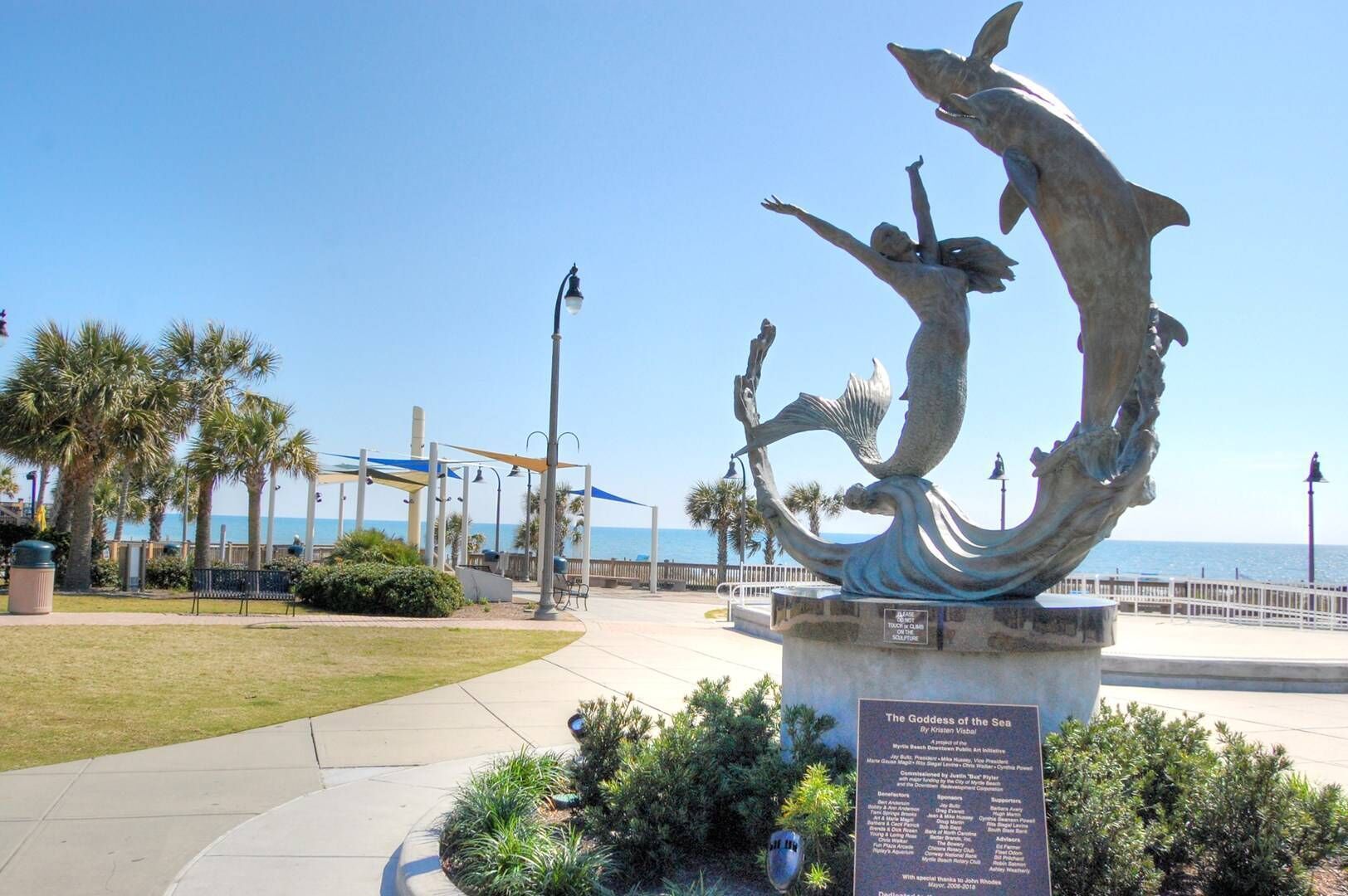 The iconic Goddess of the Sea sculpture graces this beautiful coastal area with palm trees and ocean views nearby.