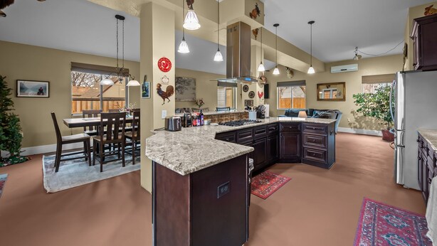 A spacious kitchen with a central island, dark cabinetry, and pendant lighting. - Hot Tub & Gym | Minutes to Red Rocks Ampitheater | Sauna (Lakewood)