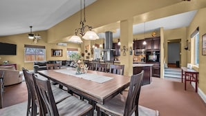 A spacious living area with a large wooden dining table, dark wooden chairs, and a ceiling fan. - Hot Tub & Gym | Minutes to Red Rocks Ampitheater | Sauna (Lakewood)
