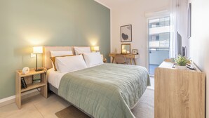 Une chambre d’hôtel moderne équipée d’un lit, de lampes de chevet, d’un bureau et d’une fenêtre.