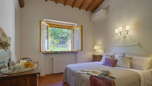Quarto com cama, janela, mesa de cabeceira e radiador.