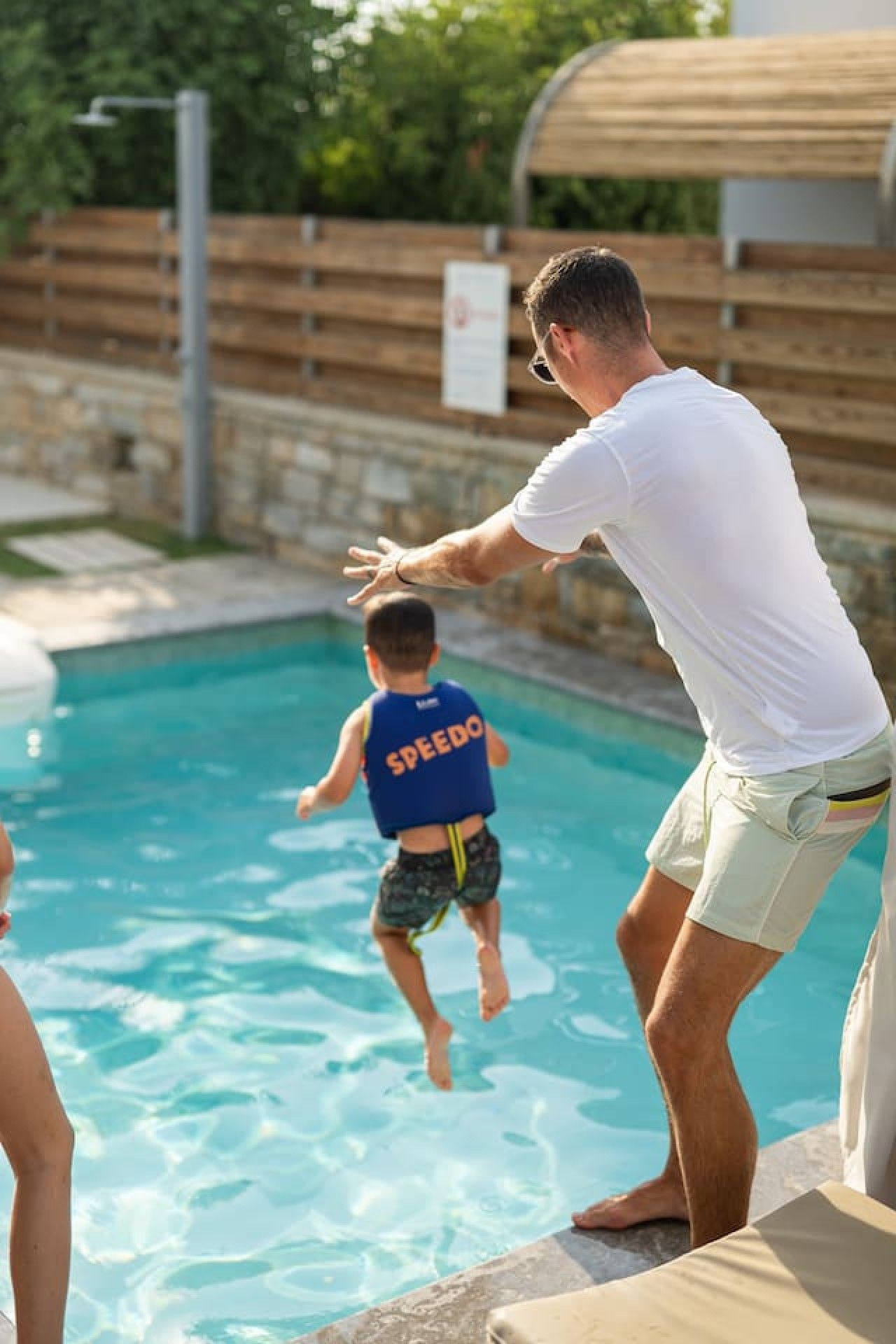 Ein Schwimmbecken mit einer Person in einem weißen Hemd und einer weiteren in einer blauen Rettungsweste.