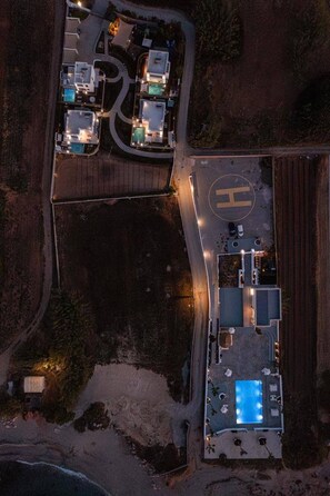 An aerial view of a property with a swimming pool, multiple buildings, and a parking area. - Eeanthe by the beach! Thalasses (rethymno)