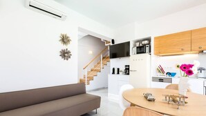 Una cocina moderna con gabinetes blancos, microondas y cafetera.