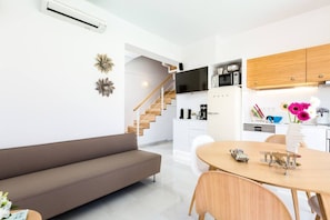 Una cocina moderna con gabinetes blancos, microondas y cafetera.