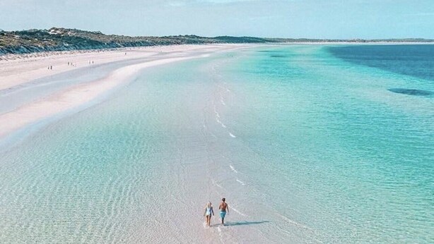 Una playa con agua turquesa cristalina y una orilla arenosa.
