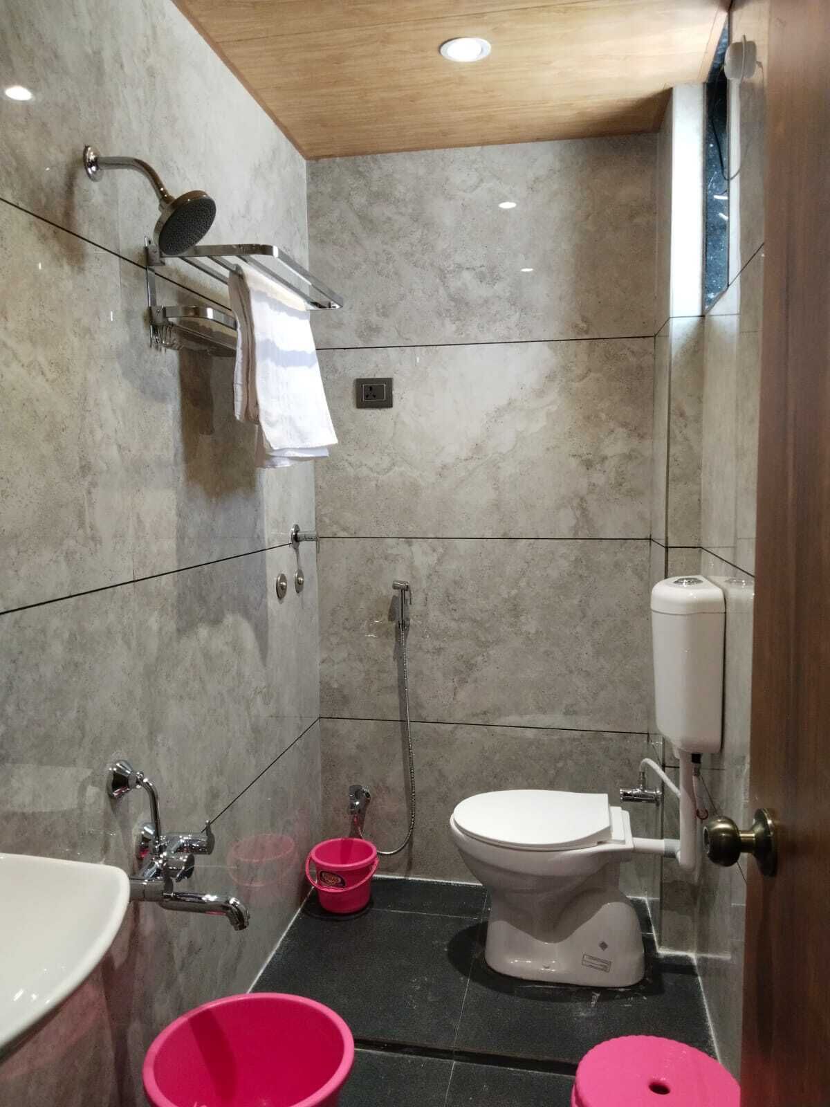 A compact bathroom with a shower, toilet, and sink.