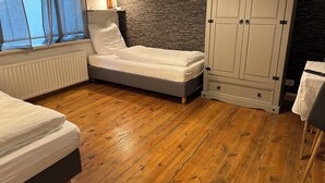 A bedroom with a bed, a wardrobe, a radiator, and a window with curtains. - Elbnahes Juwel in Hamburg Wedel (Wedel)
