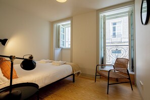 A bedroom with a bed, a chair, a desk, and a window. - Castelo Superior Two Bedroom Apartment  (Lisbon)