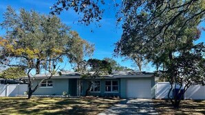 A single-story house with a front yard, a driveway, and a garage. - NEW Stunning Home-close to Beaches-pet Friendly (Largo)