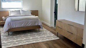 A bedroom with a bed, a ceiling fan, a window, a dresser, and a door. - NEW Stunning Home-close to Beaches-pet Friendly (Largo)