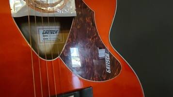 A red acoustic guitar with a white label indicating a 30% discount.